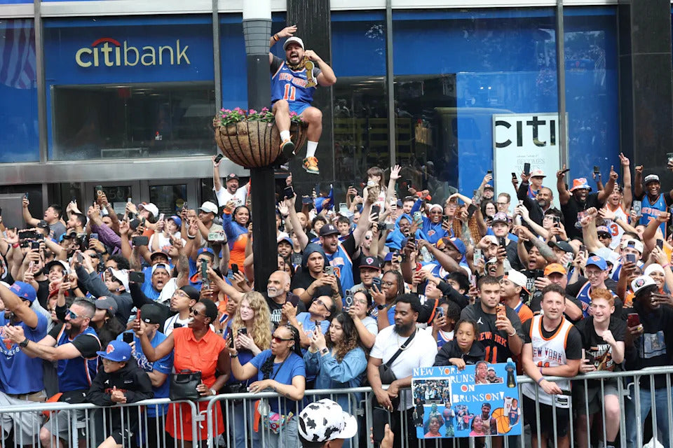 Person celebrating on a float above a crowd with Citibank and Citi logos in the background