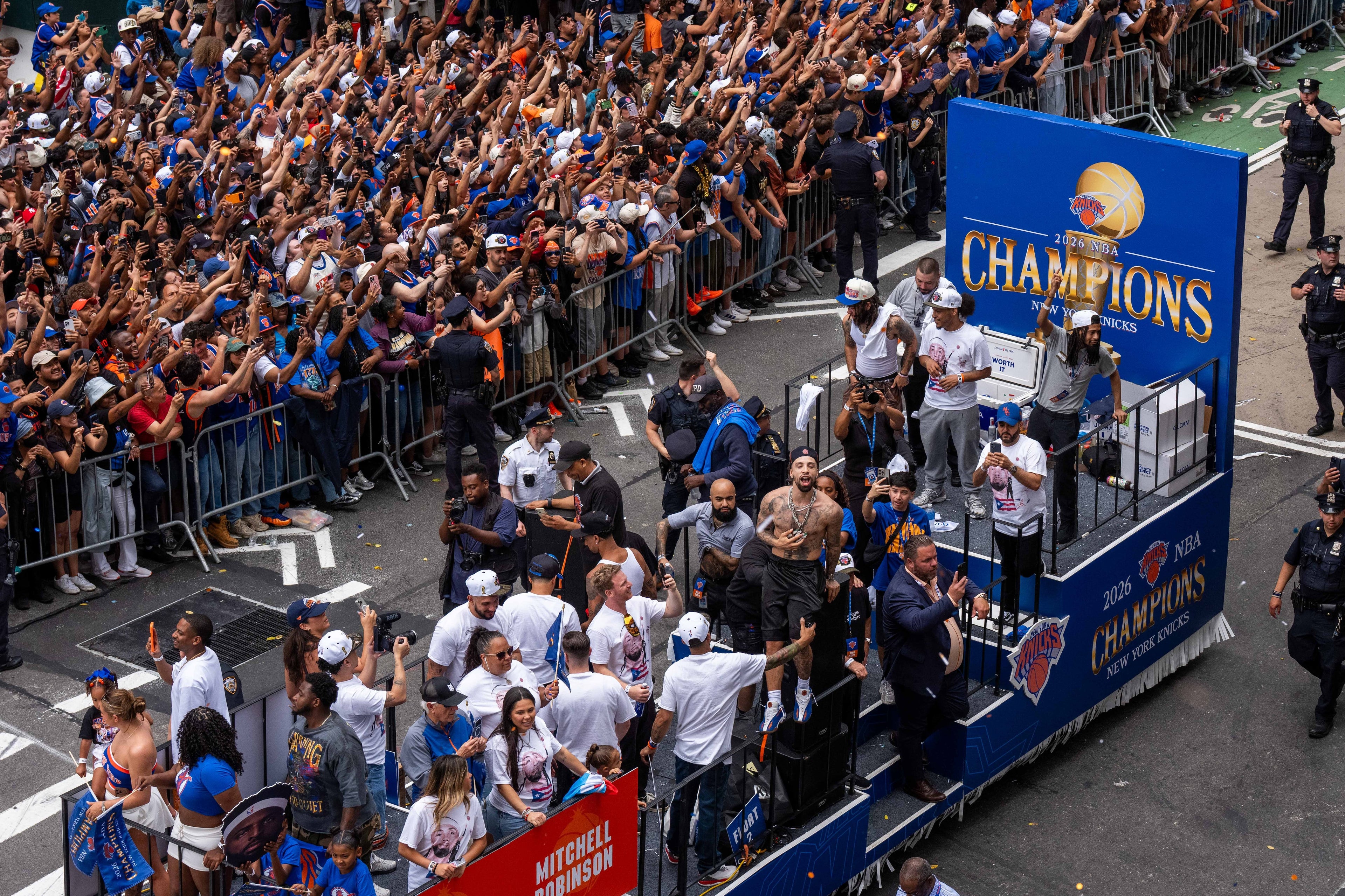 Parade with a float labeled 'Champions' and a large crowd of people cheering.