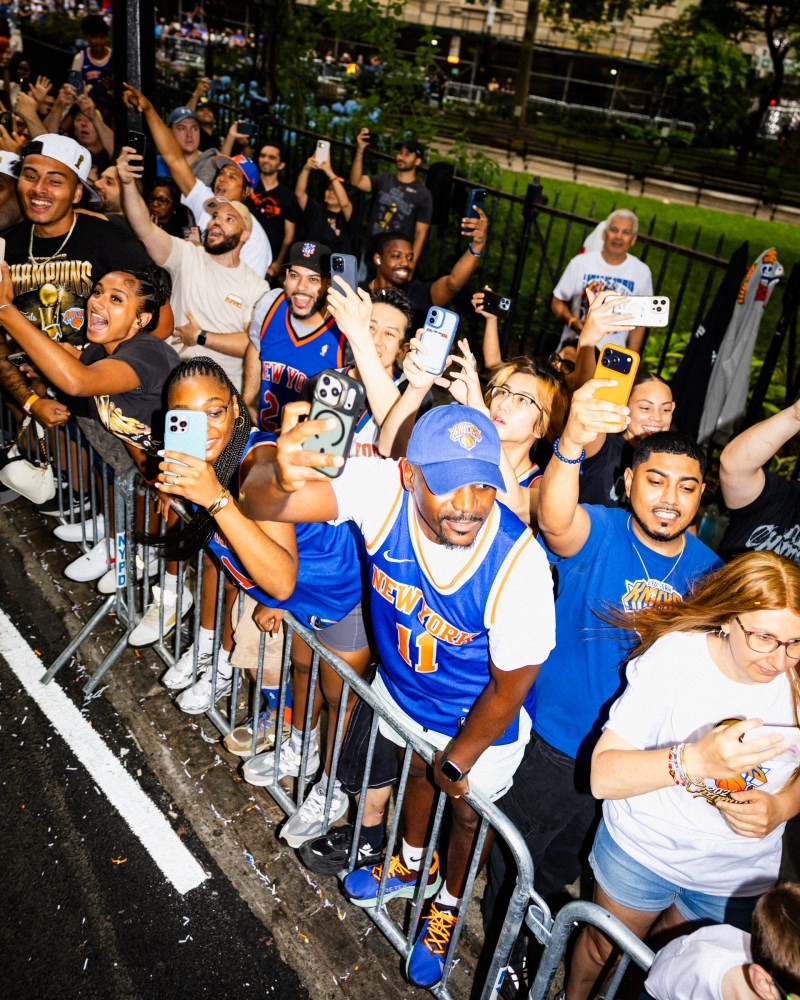 People taking photos with a person wearing a blue jersey with number 1, possibly at a sports event.