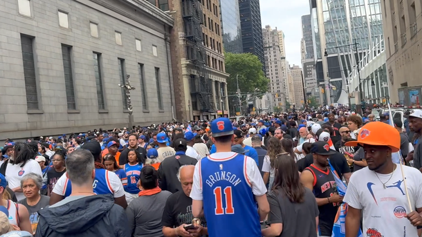 Crowd of people on a city street with buildings in the background
