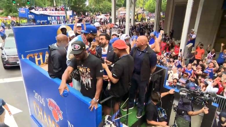 Crowd of people gathered around a blue banner with '2024 Champions' text, likely at a sports event.