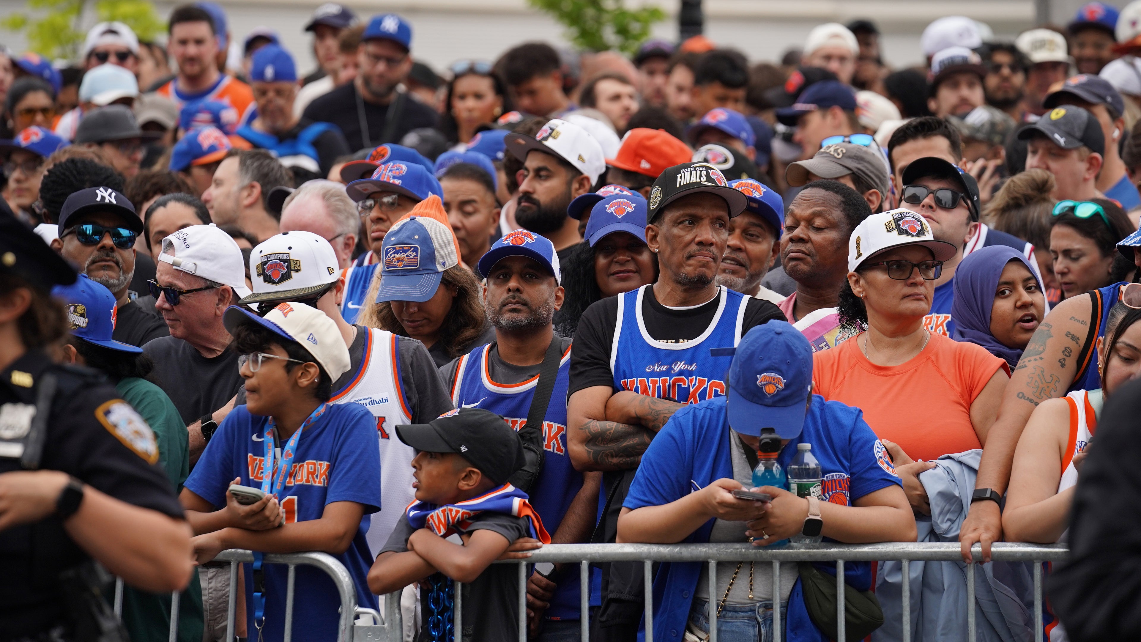 Crowd of people wearing sports team hats and shirts, likely at a sports event.