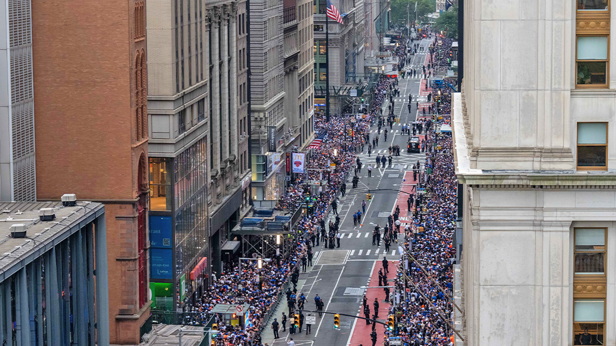 Crowded city street with people walking between tall buildings